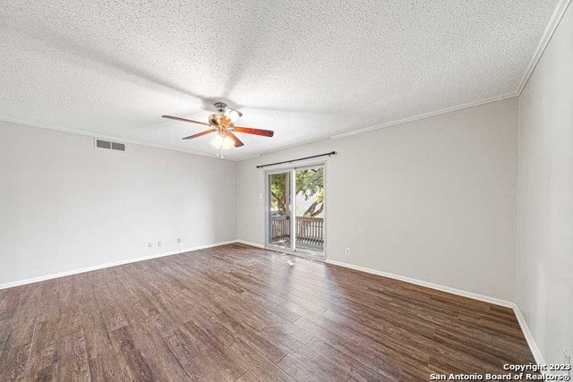 empty room with a textured ceiling, ceiling fan, ornamental molding, and dark wood-type flooring