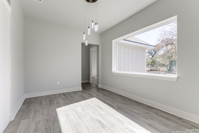 spare room with a chandelier and light hardwood / wood-style flooring