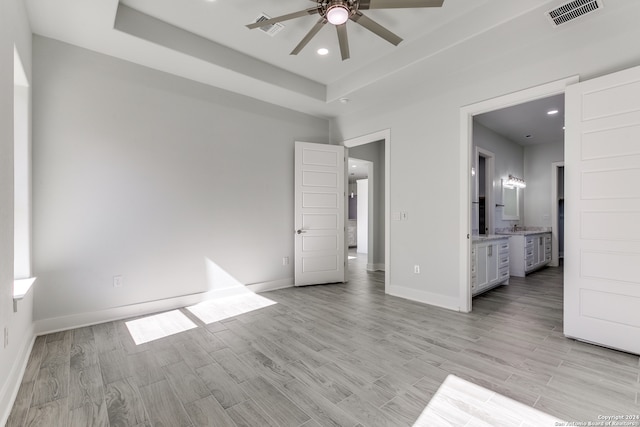 unfurnished bedroom with connected bathroom, light hardwood / wood-style floors, and ceiling fan