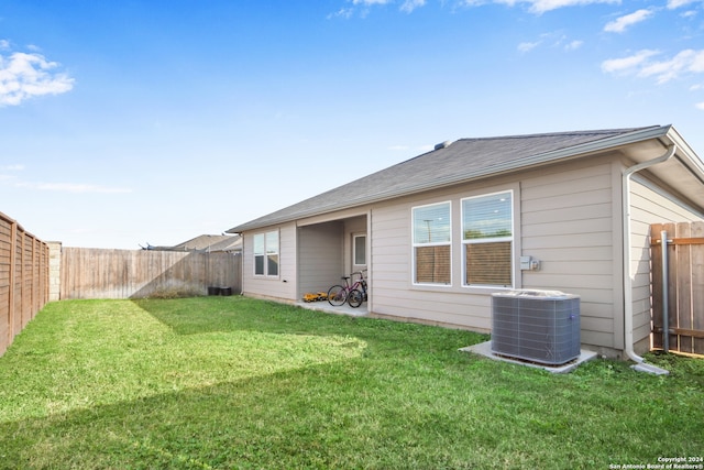 back of property with a lawn and central AC unit