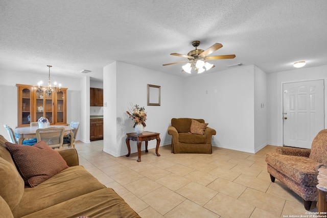 tiled living room with ceiling fan with notable chandelier and a textured ceiling