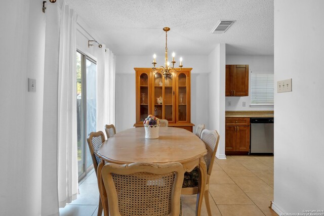 dining area featuring light tile patterned flooring, a textured ceiling, and an inviting chandelier