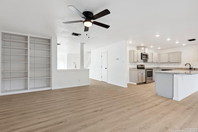 kitchen with ceiling fan, sink, light wood-type flooring, and stainless steel appliances