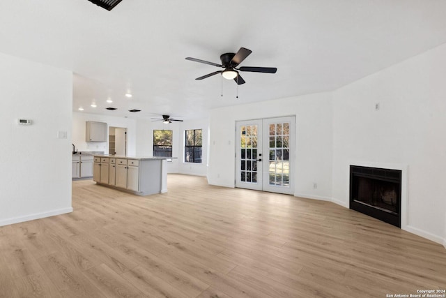 unfurnished living room featuring ceiling fan, french doors, and light hardwood / wood-style flooring