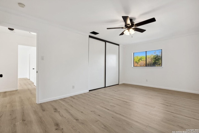 unfurnished bedroom with a closet, light hardwood / wood-style floors, ceiling fan, and ornamental molding