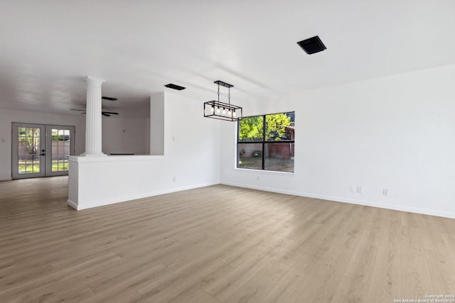 unfurnished living room featuring ceiling fan, french doors, and light hardwood / wood-style floors