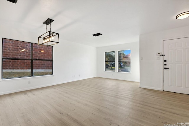 entryway featuring light wood-type flooring and a notable chandelier