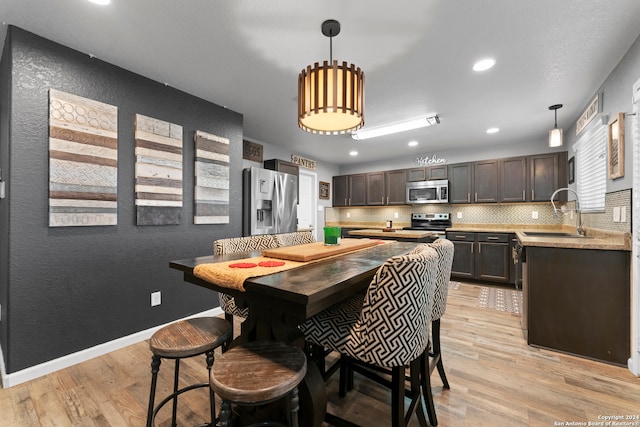 dining area featuring sink and light hardwood / wood-style flooring