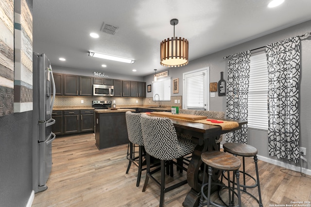 dining space with light hardwood / wood-style floors and sink