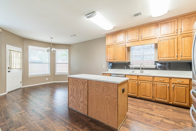 kitchen featuring dark hardwood / wood-style flooring, sink, pendant lighting, an inviting chandelier, and a kitchen island