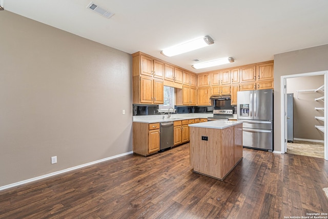 kitchen featuring a center island, stainless steel appliances, dark hardwood / wood-style floors, and sink