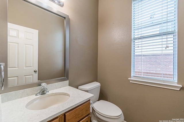 bathroom featuring vanity, a healthy amount of sunlight, and toilet