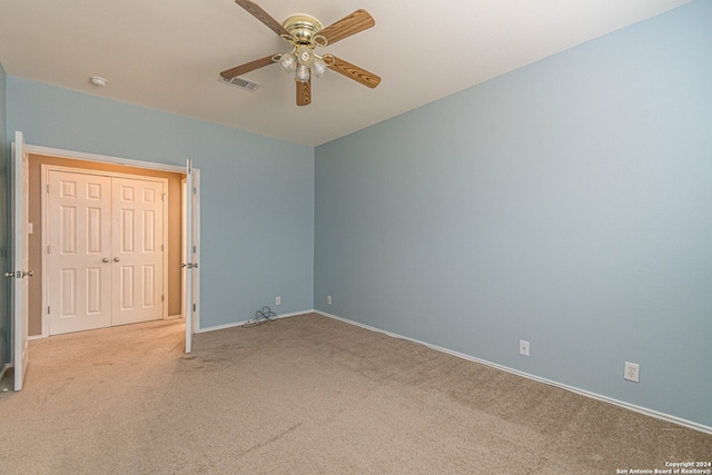 unfurnished bedroom featuring ceiling fan, a closet, and light colored carpet