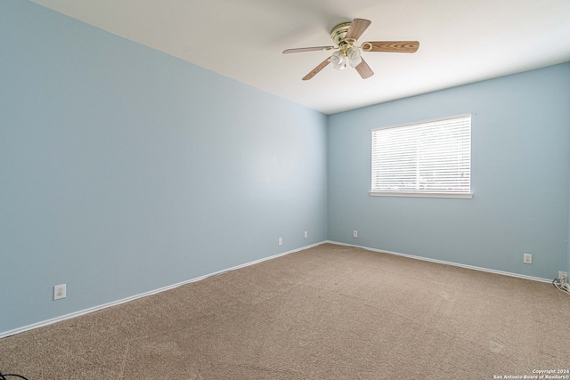 carpeted spare room featuring ceiling fan