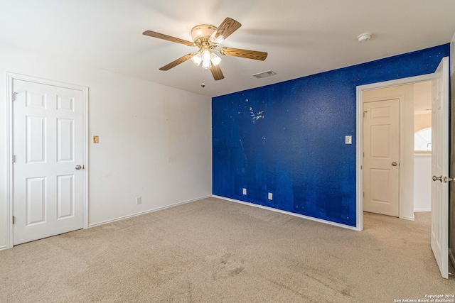 spare room featuring light colored carpet and ceiling fan