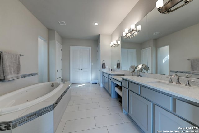 bathroom featuring a relaxing tiled tub, vanity, tile patterned flooring, and a notable chandelier