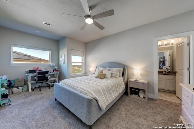 carpeted bedroom with ceiling fan and ensuite bath