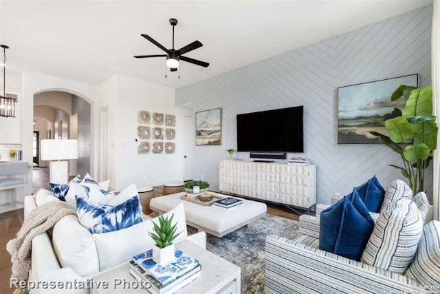 living room featuring ceiling fan with notable chandelier and hardwood / wood-style flooring