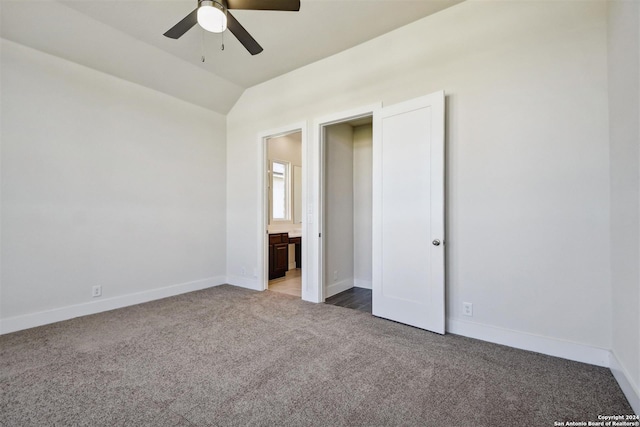 unfurnished bedroom with ceiling fan, carpet floors, ensuite bathroom, and vaulted ceiling