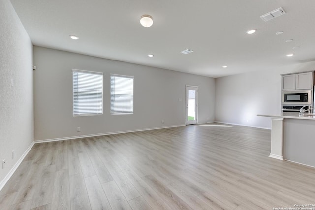 unfurnished living room featuring light wood-type flooring