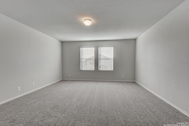 carpeted spare room with a textured ceiling