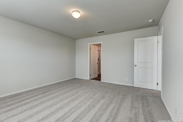 unfurnished room featuring light carpet