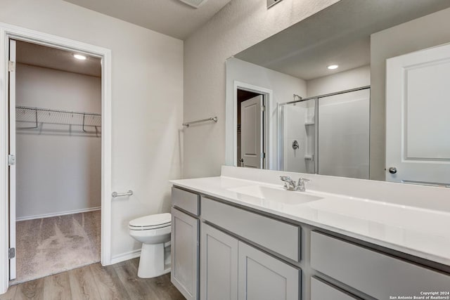 bathroom with vanity, toilet, wood-type flooring, and walk in shower