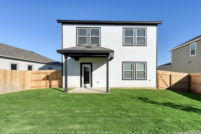 rear view of property with a yard and a patio