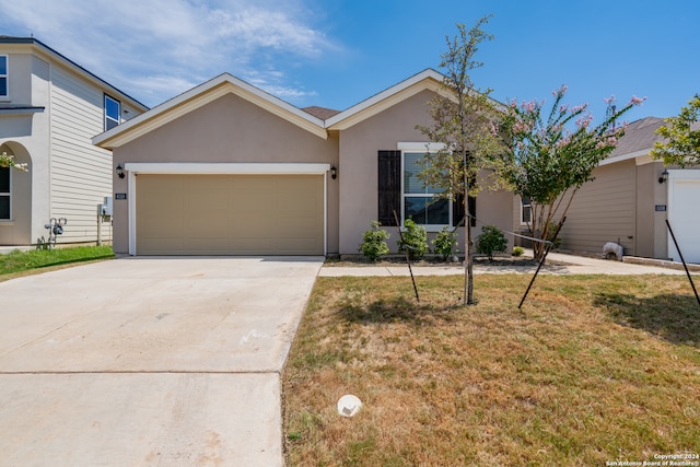 ranch-style house with a garage and a front lawn