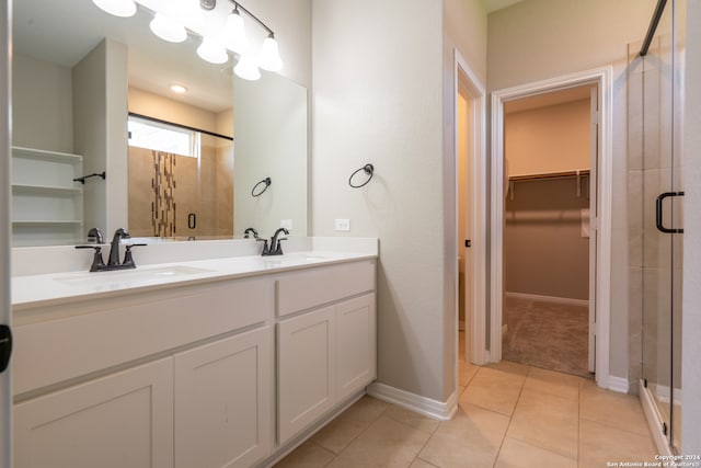 bathroom with tile patterned floors, vanity, and a shower with door