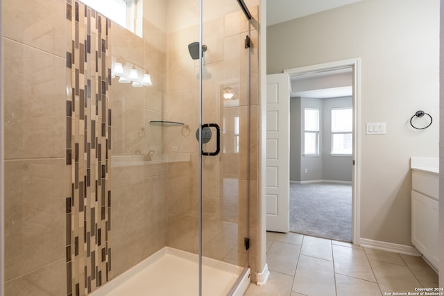 bathroom featuring tile patterned flooring, vanity, and a shower with shower door