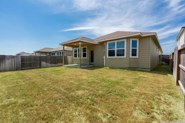 back of house featuring a patio area and a lawn