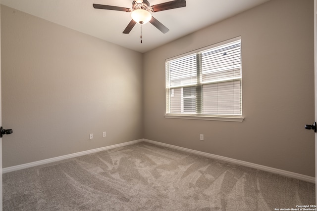 carpeted spare room featuring ceiling fan