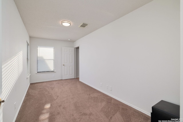 carpeted spare room featuring a textured ceiling