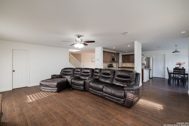 living room featuring ceiling fan and dark hardwood / wood-style floors