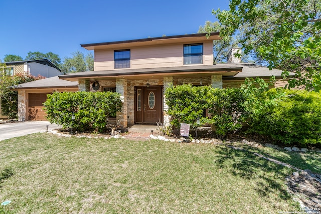 view of front of home with a front yard and a garage