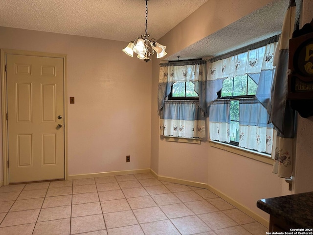 15618 Elks Pass St, San Antonio, TX 78232 - unfurnished dining area with a textured ceiling, a chandelier, light tile patterned flooring, and baseboards