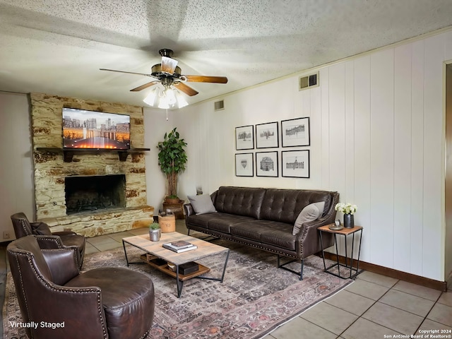 15618 Elks Pass St, San Antonio, TX 78232 - tiled living room featuring ceiling fan, a fireplace, a textured ceiling, and baseboards