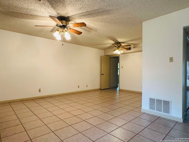 15618 Elks Pass St, San Antonio, TX 78232 - spare room featuring a ceiling fan, a textured ceiling, light tile patterned floors, and baseboards