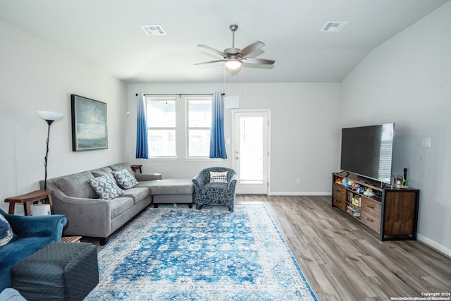 living room with ceiling fan, light hardwood / wood-style floors, and lofted ceiling