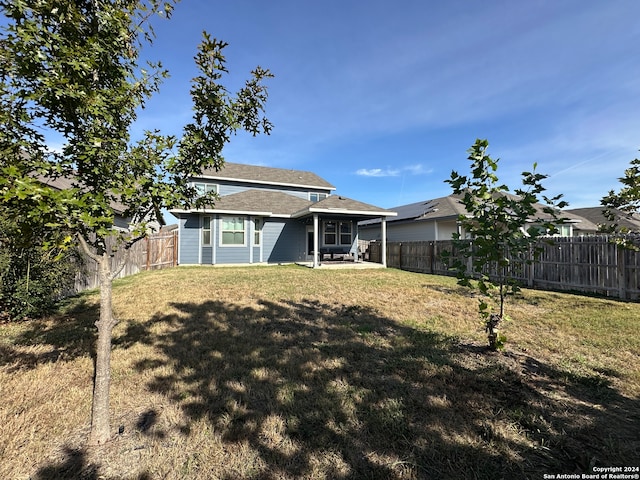 rear view of property with a yard and a patio