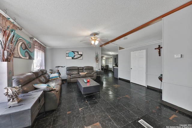 living room featuring ceiling fan, ornamental molding, and a textured ceiling