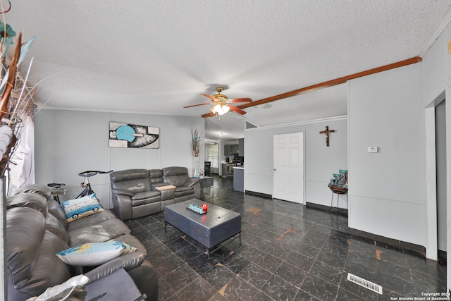 living room with crown molding, ceiling fan, and a textured ceiling