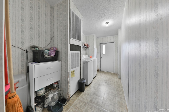 laundry area with washing machine and dryer and a textured ceiling