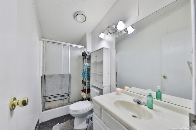 bathroom with an enclosed shower, a textured ceiling, vanity, tile patterned flooring, and toilet