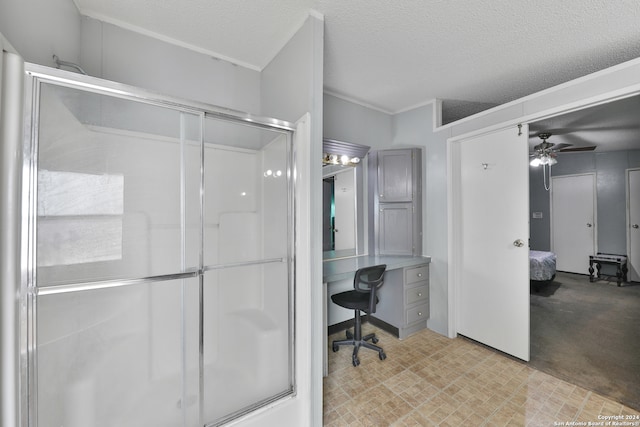 bathroom with ceiling fan, a shower with shower door, and a textured ceiling