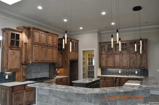 kitchen featuring pendant lighting, decorative backsplash, a kitchen island, and light stone countertops