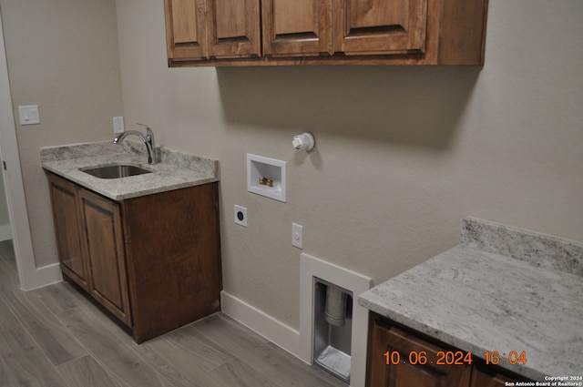 washroom featuring cabinets, hookup for a washing machine, hookup for an electric dryer, sink, and light hardwood / wood-style floors