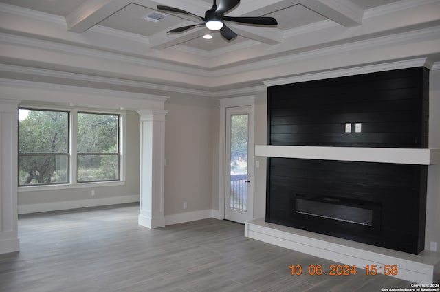 unfurnished living room with a wealth of natural light, crown molding, ceiling fan, and beamed ceiling