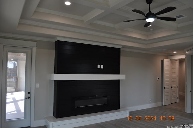 unfurnished living room featuring a large fireplace, coffered ceiling, beamed ceiling, crown molding, and hardwood / wood-style floors